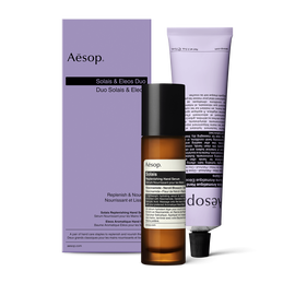 A pump bottle of Solais Replenishing Hand Serum and a tube of Eleos Aromatique Hand Balm together in a carboard box.